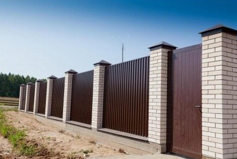 распашные ворота и калитка в заборе из профлиста между кирпичными столбами